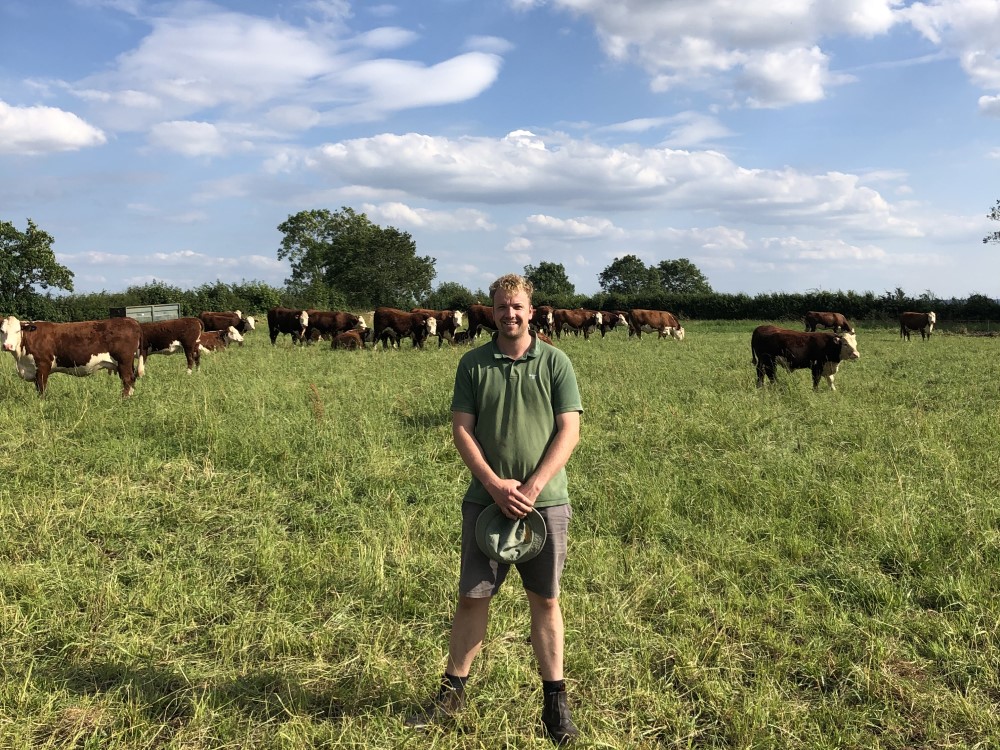 Farmer Greg Parkes standing in a field of cows
